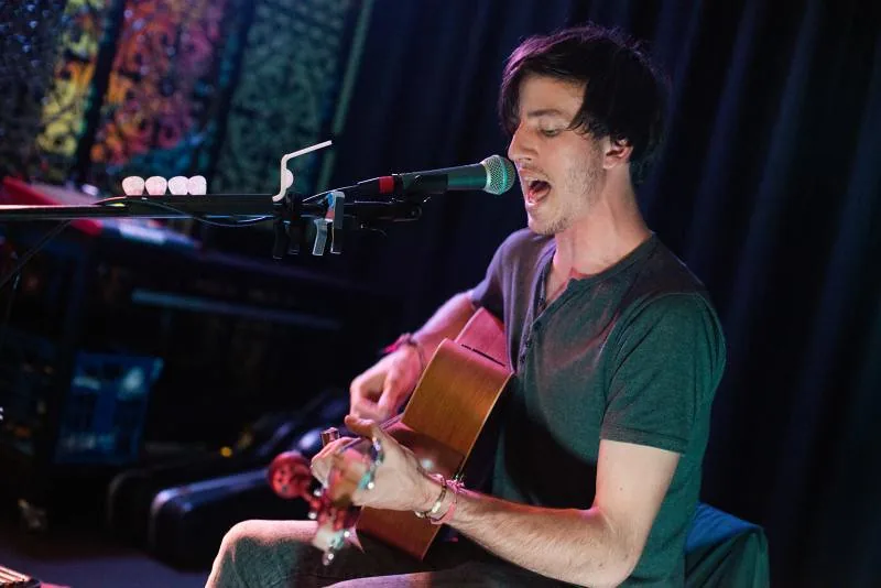 James Bennett singing and playing acoustic guitar