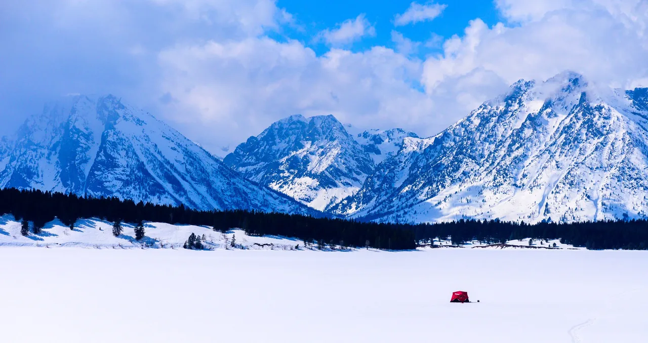 The snow-covered Teton Range above a frozen plain